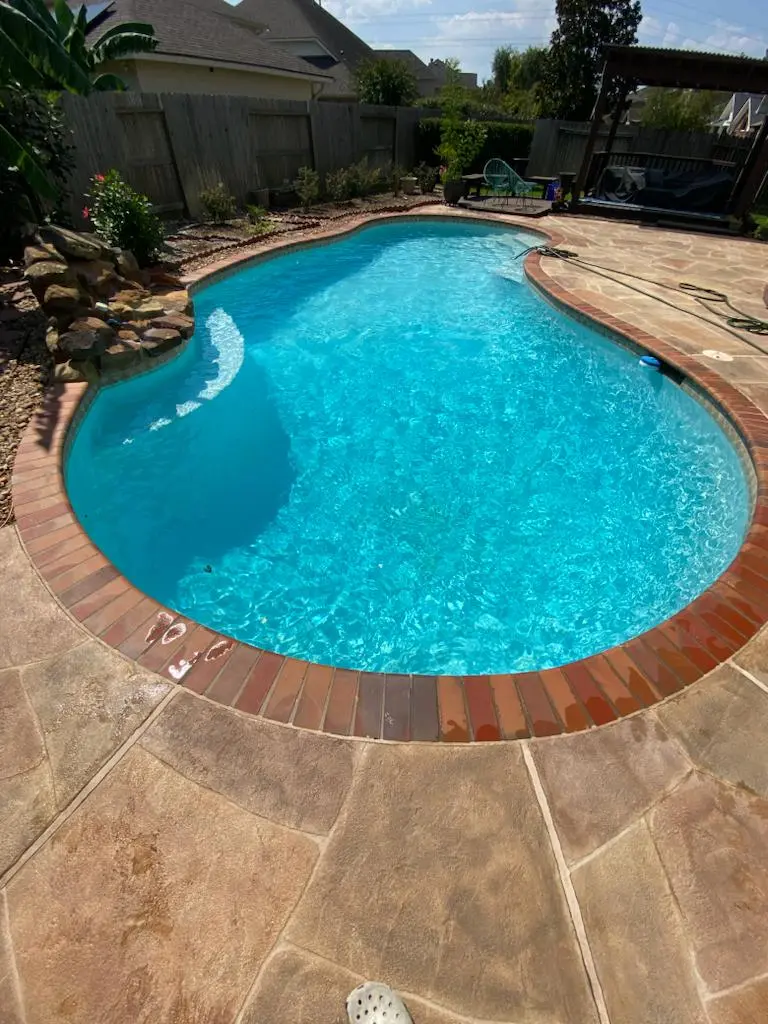 Kidney-shaped pool with brick coping