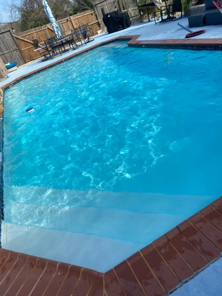 Crystal clear blue pool with brick coping